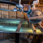 Reverse osmosis sap releaser sitting above a full stainless steel tank inside a maple sugar house.
